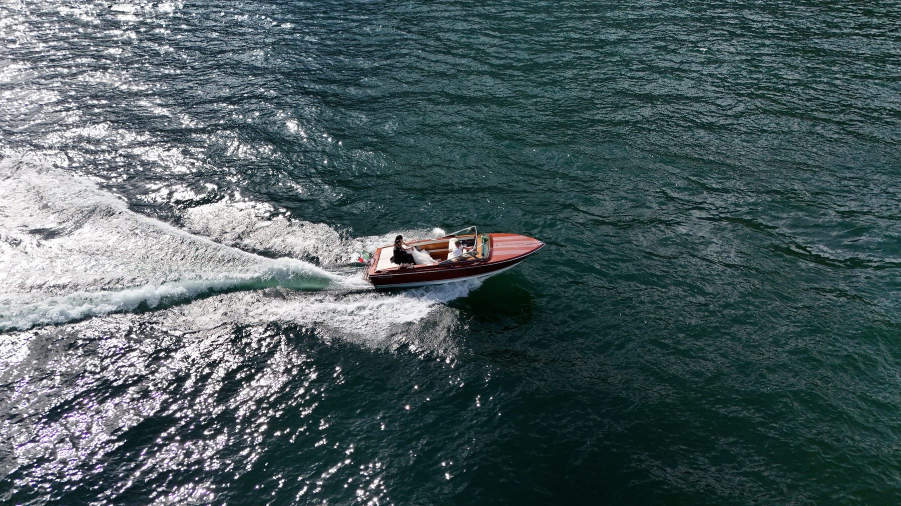 The boat cutting a wake across the lake, seen from above