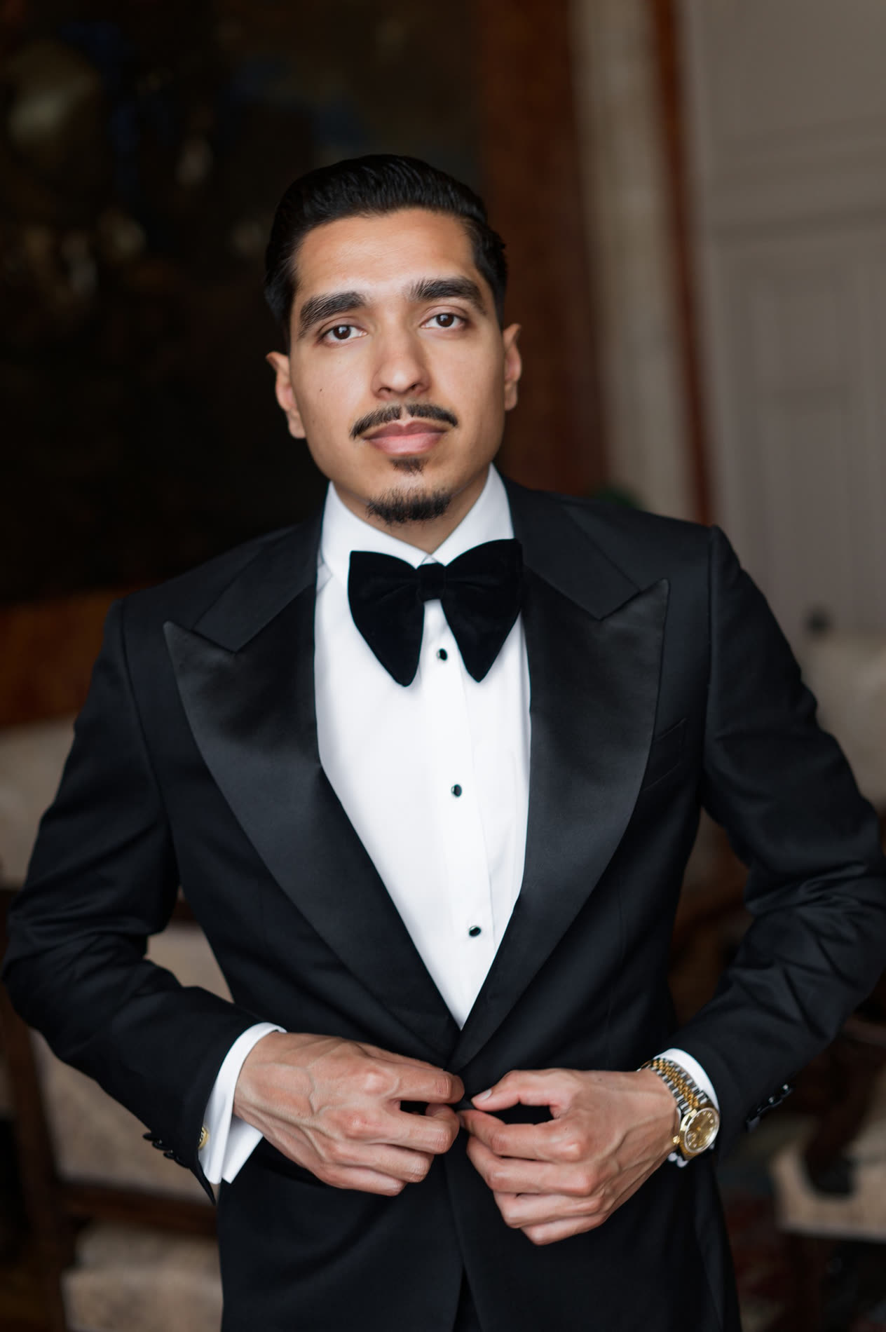 A groom fastening his Conxeppt custom tuxedo jacket